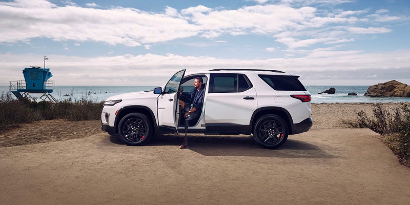 side view of white chevy traverse with one door open
