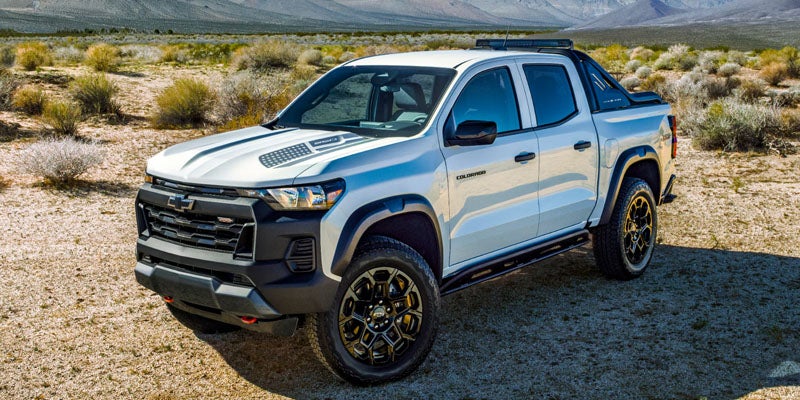Blue chevy colorado left side view on dessert
