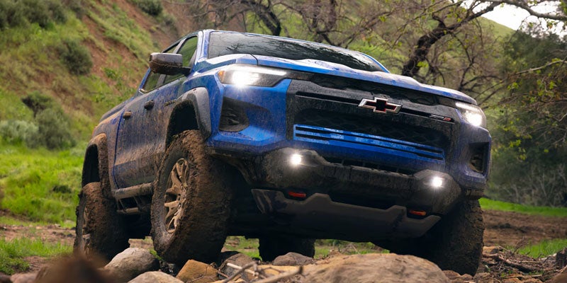 Blue chevy colorado side view on dessert